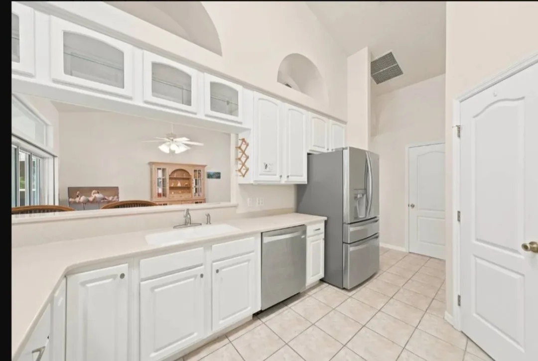 White kitchen cabinets, counters and tile floors cleaned in a Cocoa, FL home